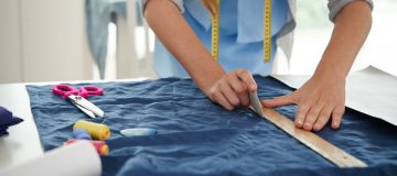 Hands of tailor drawing on fabric before sewing